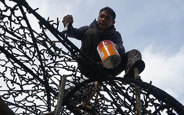 Local man painting the sculpture at the Lubi Art Project. 