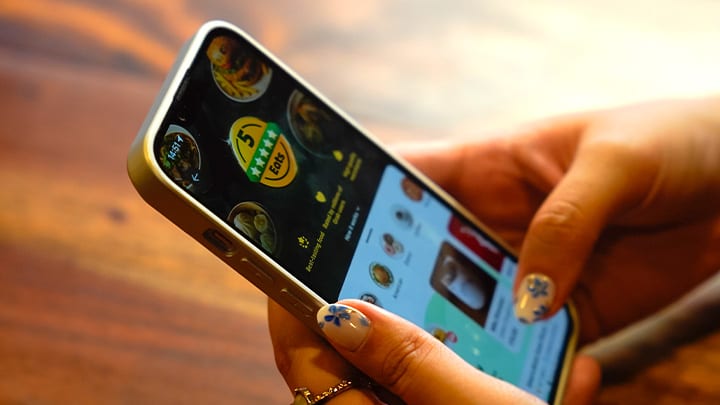 A hand holding a phone with the GrabFood app opened.